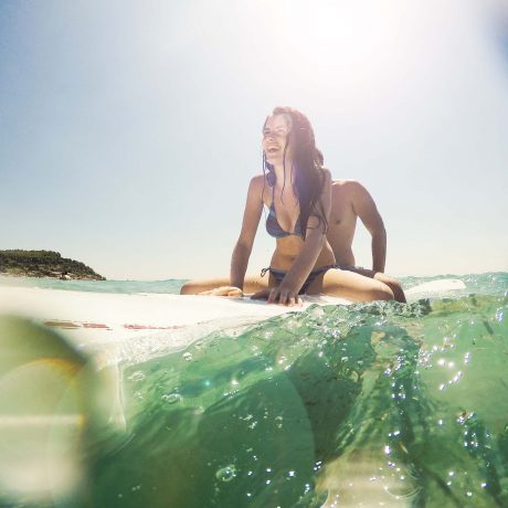 Love Couple surfing the waves and have a great time at summer holliday